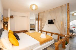 a bedroom with a canopy bed with yellow pillows at Little Garden in Pera Gyalos
