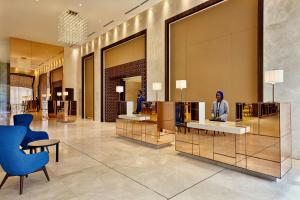 a hotel lobby with a woman sitting at a counter at Sheraton Nouakchott Hotel in Nouakchott +68 photos