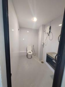 a white bathroom with a toilet in a room at Hi-Inn in Miri