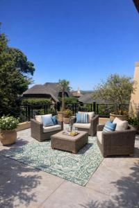 a patio with couches and chairs on a rug at The Gables Boutique Hotel in Chintsa