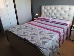 a bedroom with a bed with a quilt on it at Cá Morten in Santa Maria