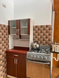 a kitchen with a stove and wooden cabinets at Apu Wasi in Cusco