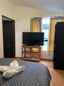 a bedroom with a bed and a flat screen tv at Apu Wasi in Cusco