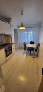 a kitchen and dining room with a table and chairs at Sara Apartment Centru Râmnicu Vâlcea in Râmnicu Vâlcea +10 photos