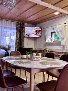 a dining room with a table and chairs and a tv at Atpūta Mālpilī in Mālpils