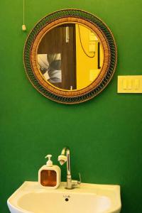 a green bathroom with a sink and a mirror at House Of Green Flag VIP ROAD Baguiati Kolkata in kolkata