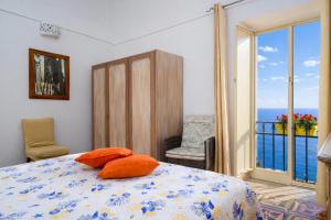 a bedroom with a bed and a balcony with the ocean at A la casa del cavaliere in Positano