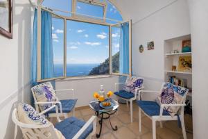 a room with chairs and a table and a large window at A la casa del cavaliere in Positano