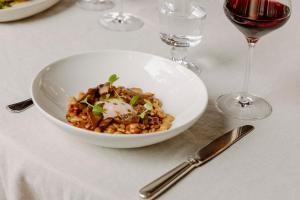 a white bowl of food on a table with wine glasses at Mas de Torrent Hotel & Spa, Relais & Châteaux in Torrent