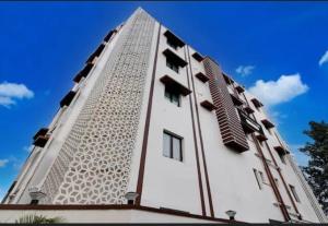 a tall white building with windows on top of it at Creek Row in Kolkata