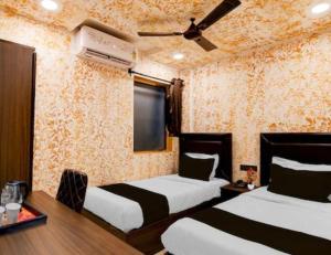 a hotel room with two beds and a tv at Creek Row in Kolkata