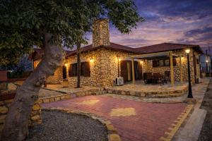 a stone house with a brick patio in front of it at Villa Thalia in Alexandroupoli