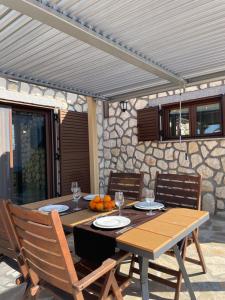 a wooden table with chairs and a table with wine glasses at Villa Thalia in Alexandroupoli