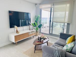 a living room with a couch and a table at Ático frontal al mar en Duna Beach con vistas in Torrox Costa