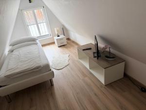 a bedroom with a bed and a desk and a window at Ferienwohnung Brigitta in Hambühren