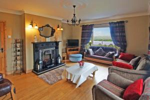 a living room with a fireplace and a table at 6 Bed in Clonbur oc-i275 in Finny