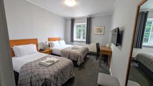 a hotel room with two beds and a desk at Quality Hotel Coventry in Coventry