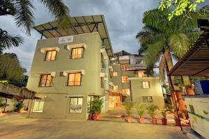 a large building with palm trees in front of it at Kohinoor Exotica in Lonavala