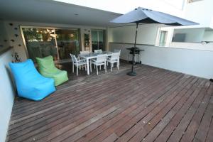 a deck with a table and chairs and an umbrella at Foz Palace - Praia da Rocha in Portimão