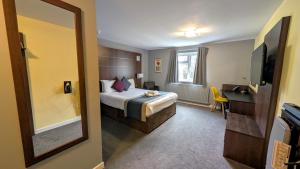 a hotel room with a bed and a mirror at Quality Hotel Coventry in Coventry