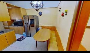 a small kitchen with a table and a refrigerator at private room in Seveso