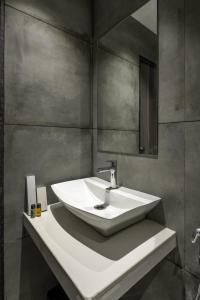 a bathroom with a white sink and a mirror at Hotel Hycon in Kozhikode