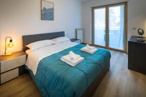 a bedroom with a large bed with two towels on it at - Magenta Apartment - in Monfalcone