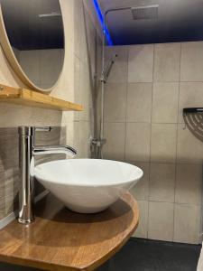 a white sink on a wooden counter in a bathroom at Gîte en Sarthe avec sauna et jacuzzi in Saint-Georges-du-Rosay +20 photos