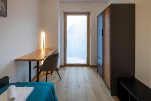 a room with a desk and a bed and a table at - Magenta Apartment - in Monfalcone