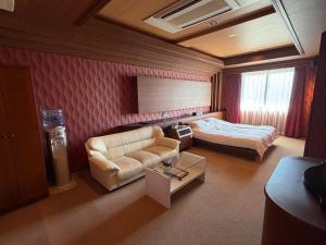 a hotel room with a bed and a couch at HOTEL AMARIS & HIP (Adult Only) in Kanazawa