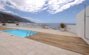 a house with a swimming pool and a wooden deck at MSV Beach in Puerto Naos