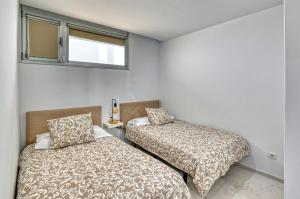 a bedroom with two beds and a window at MSV Beach in Puerto Naos