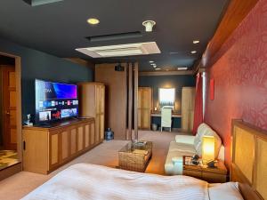 a bedroom with a bed and a flat screen tv at HOTEL AMARIS & HIP (Adult Only) in Kanazawa +10 photos