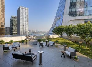 a man sitting on a couch on a rooftop of a building at Conrad Hangzhou in Hangzhou
