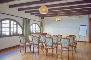 a room with a group of chairs and a board at Petit Hotel Ses Rotges - Only Adults in Cala Ratjada