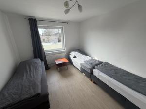 a bedroom with two beds and a window at Kwatera pracownicza Leszno in Leszno