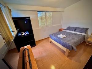 a small bedroom with a bed and a window at Apu Wasi in Cusco