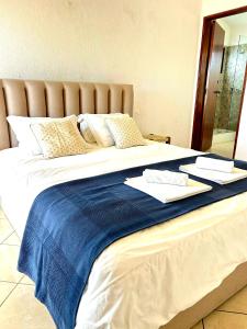 a large white bed with a blue blanket on it at Vila Praia Apartment in Albufeira