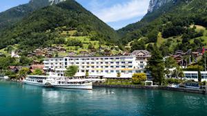 a hotel on the river with mountains in the background at BEATUS Wellness- & Spa-Hotel in Merligen