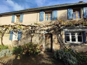 an old stone house with a tree in front of it at Gîte Léon, Beynat, Corrèze in Beynat