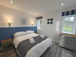 a bedroom with a large bed with two towels on it at 1 Bed in Isle Of Arran oc-96463 in Dougarie