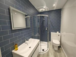 a blue tiled bathroom with a sink and a toilet at 1 Bed in Isle Of Arran oc-96463 in Dougarie +6 photos