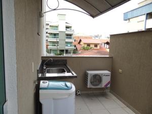 balcón con fregadero y aire acondicionado en Novo Lar 1 Bombinhas (Eliseos), en Bombinhas
