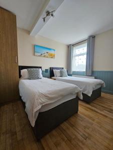 a bedroom with two beds and a window at Argyle Lodge in Rush