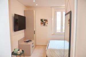 a small bedroom with a bed and a tv at DomuS Miniato in San Miniato