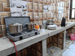 a kitchen with pots and pans on a stove at Guest House ETE-D Plus in Bohicon