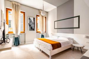 a white bedroom with a bed and a desk at Truly Verona in Verona