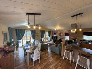 a kitchen and a living room with a table and chairs at Luxury Lakeside Lodge L1 with hot tub situated at Tattershall Lakes Country Park in Tattershall