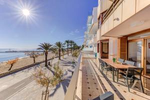 a balcony with a table and chairs and the beach at Emma Beachfront Apartment by Sealand Villas in Port de Pollensa