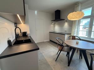 a kitchen with a sink and a table with chairs at Apartament Kirkor przy Dworku Bielin in Bielin +9 photos